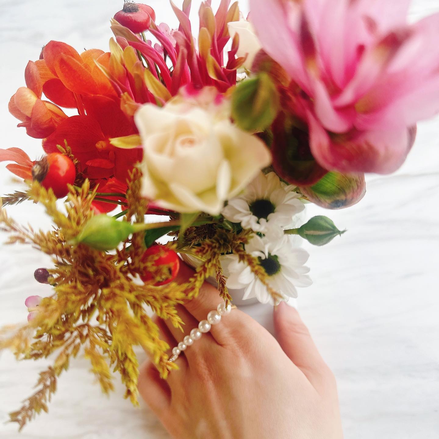 Akoya Pearl Double Finger Ring on model hand with flowers in the background