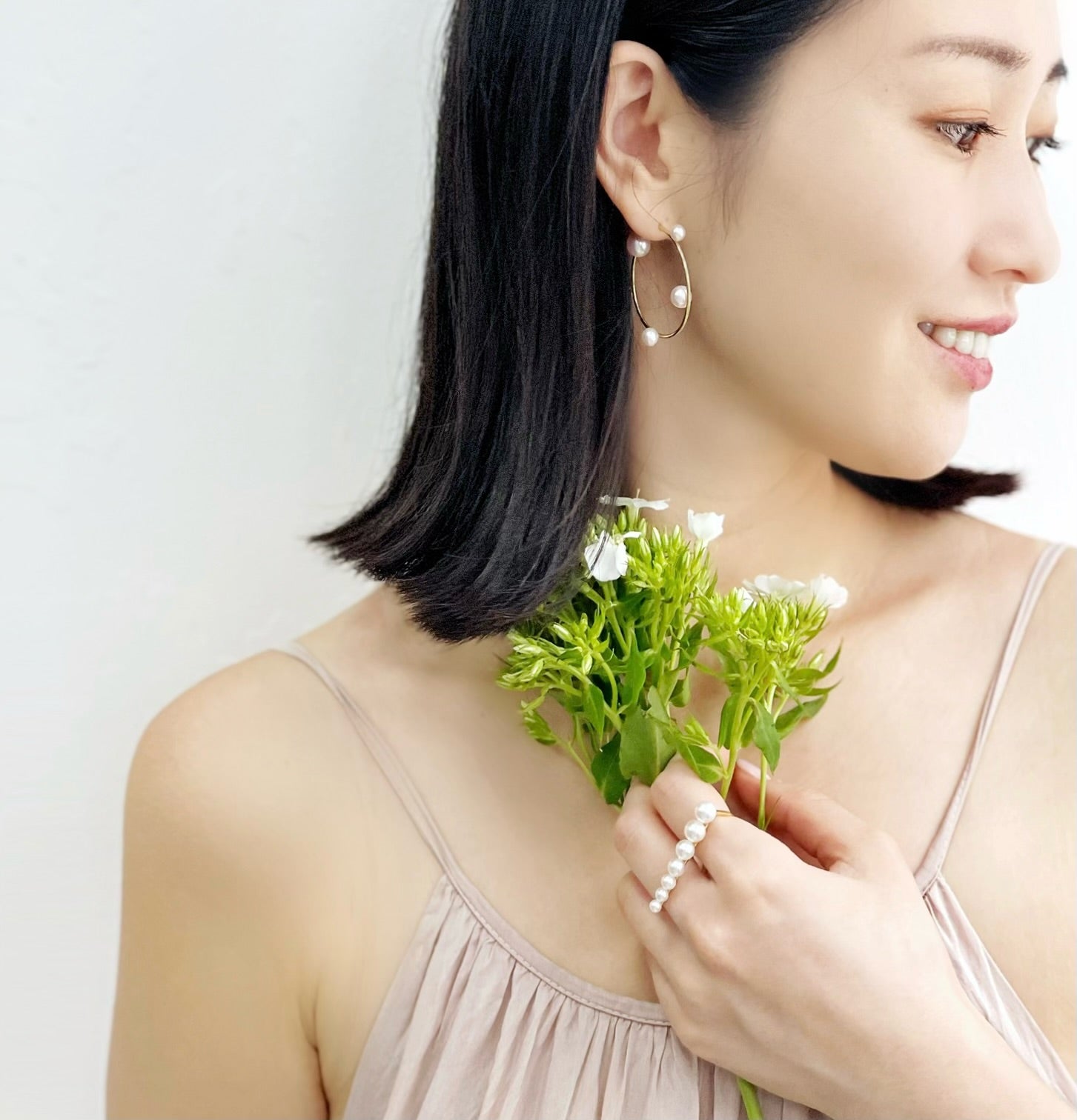 Asian woman wearing Akoya Hoop Earrings paired with Akoya Pearl Double Finger Ring