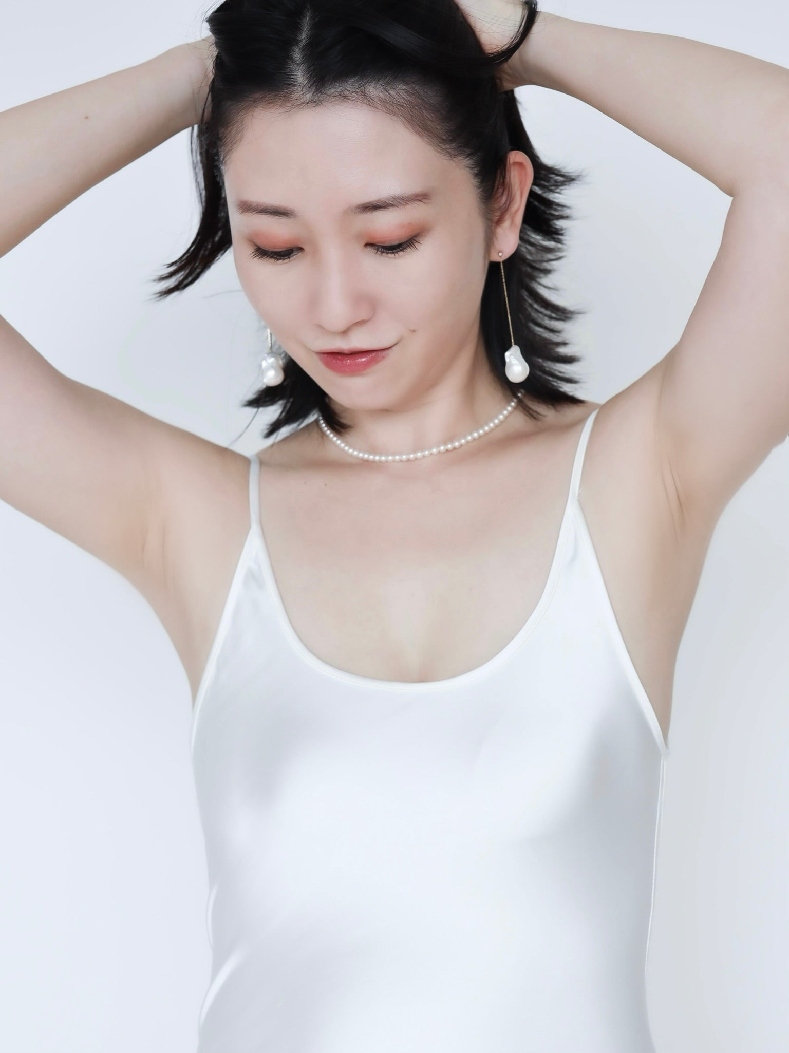 Asian woman wearing Baroque Pearl Swing Earrings paired with Akoya Baby Pearl Classic Necklace