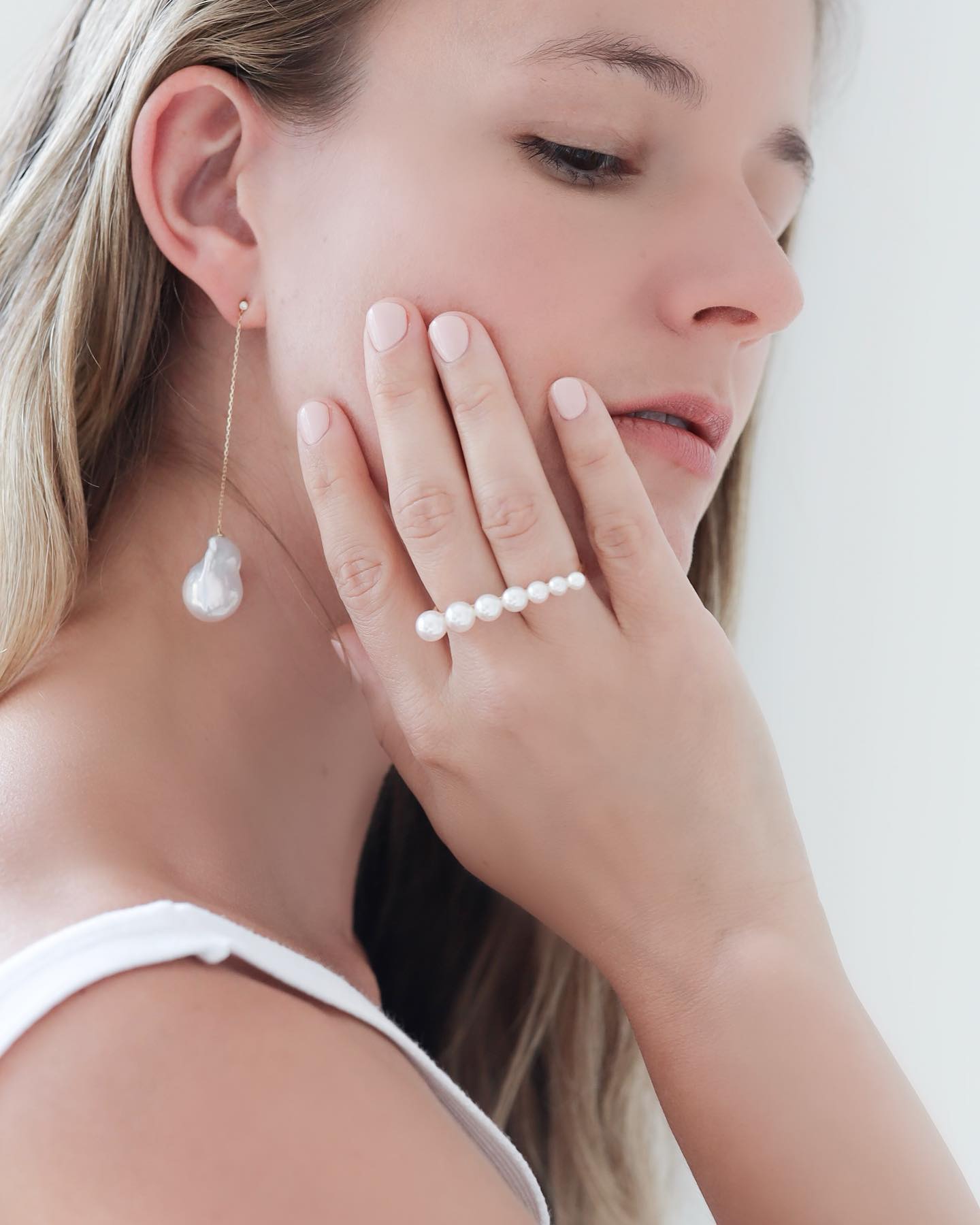 Woman wearing Baroque Pearl Swing Earrings paired with Akoya Pearl Double Finger Ring