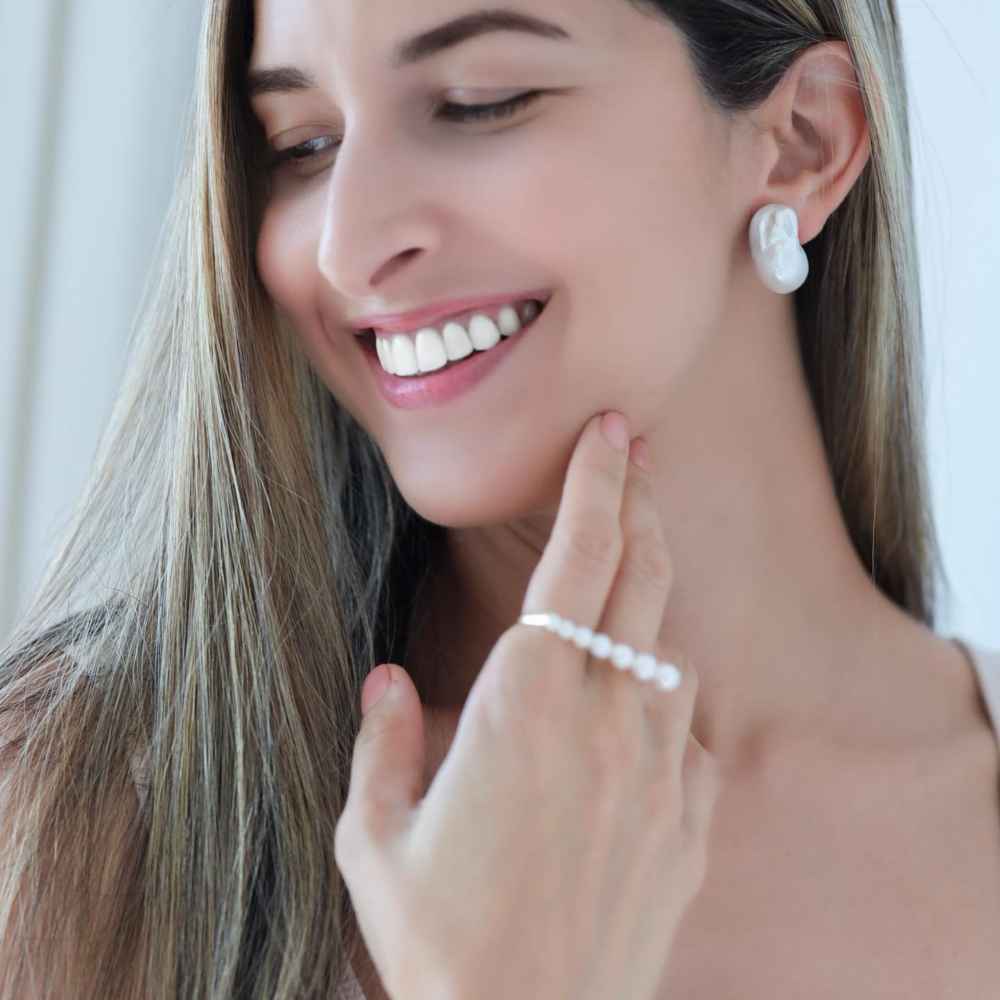 Woman wearing Baroque Pearl Stud Earrings paired with Akoya Pearl Double Finger Ring