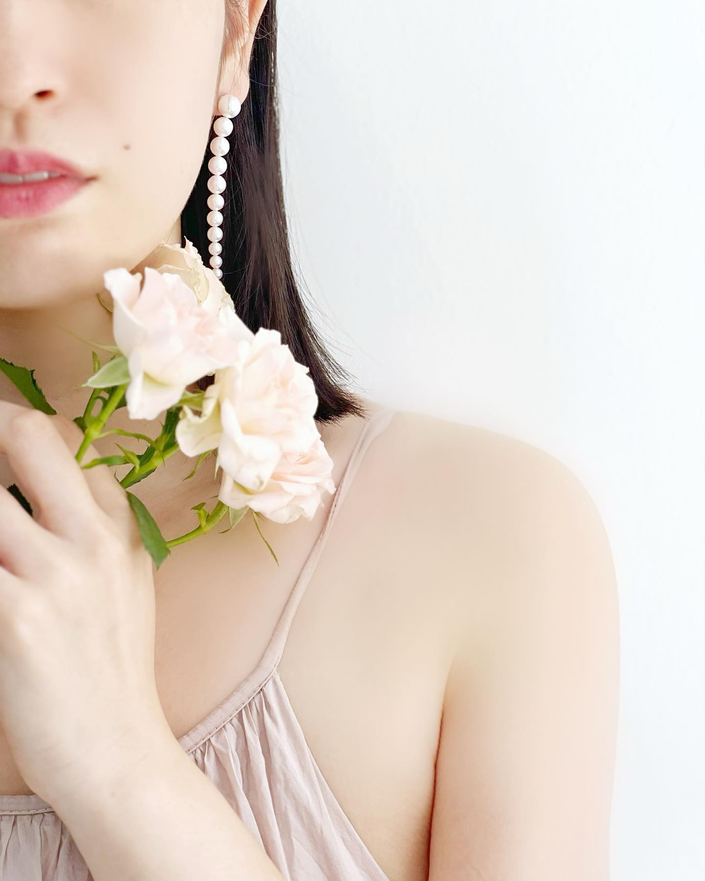 Woman wearing Akoya Gradation Earrings while holding some flowers