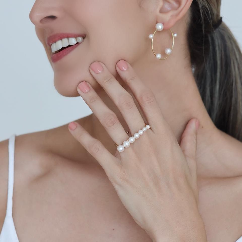 Woman wearing Akoya Hoop Earrings paired with Akoya Pearl Double Finger Ring