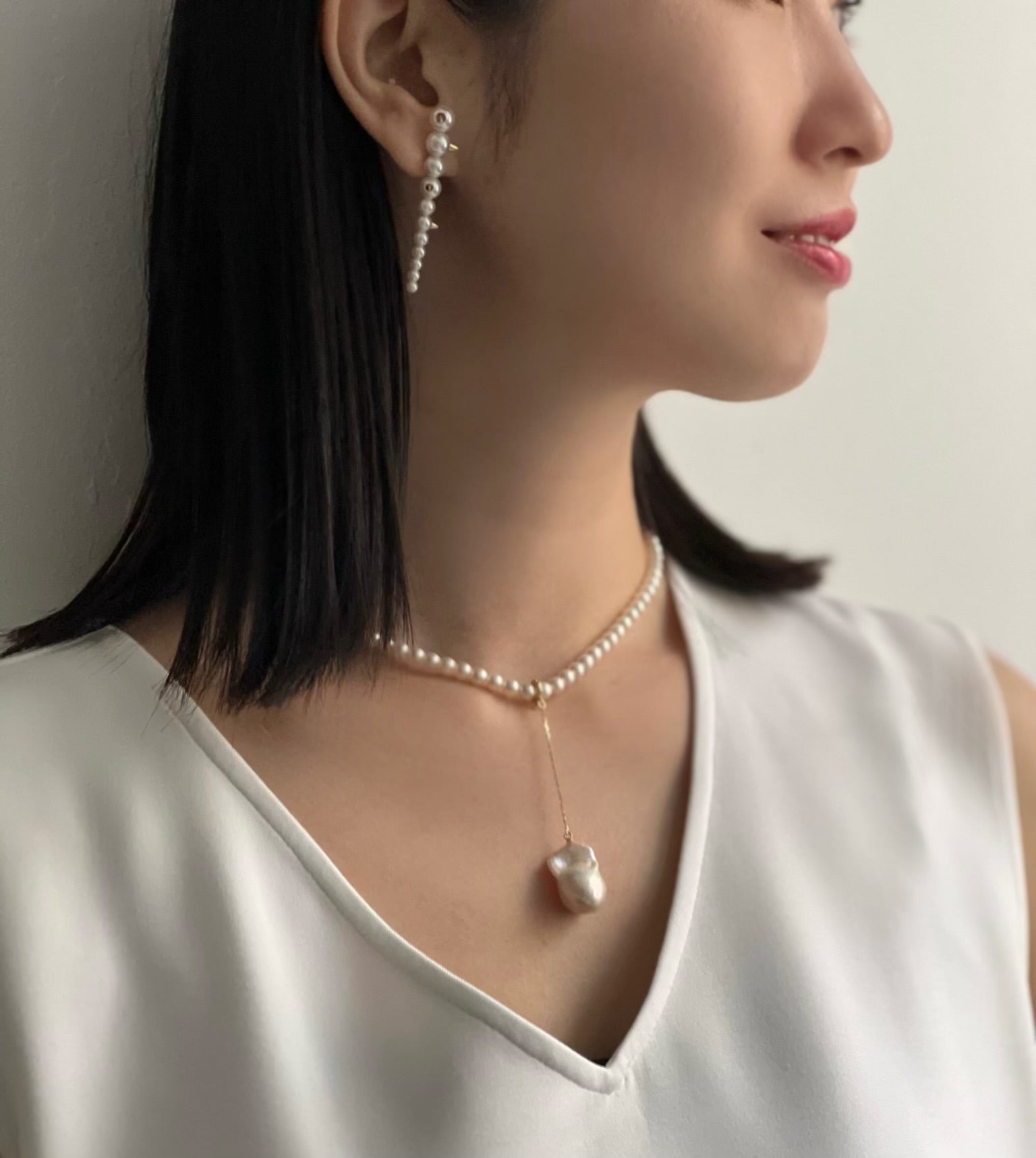 Asian Woman wearing Akoya Gold Studs Earring on ear and Akoya Baby Pearl Classic Necklace with a Baroque Pearl Charm hooked onto the necklace