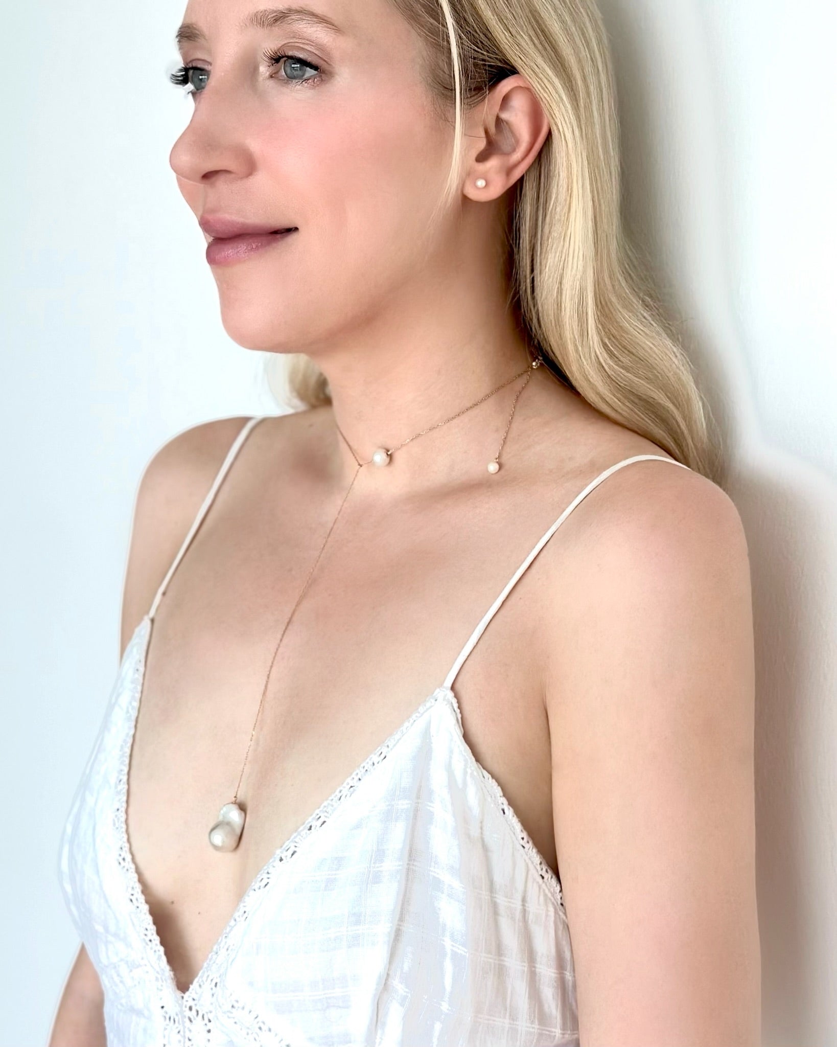 White woman wearing Akoya Baby Pearl Classic Earrings and Baroque Long Necklace