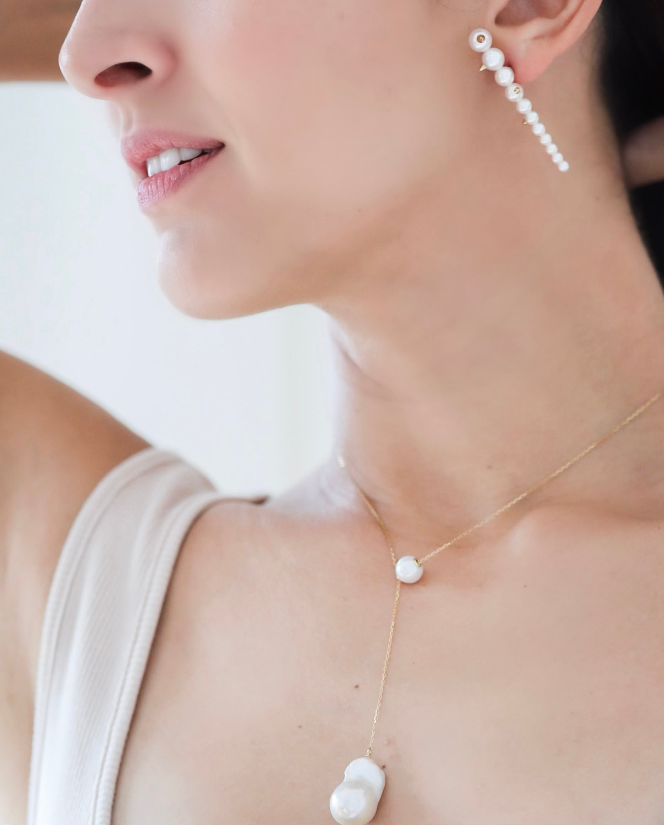 Closeup of woman pairing Akoya Gold Studs Earrings with Baroque Pearl Long Necklace